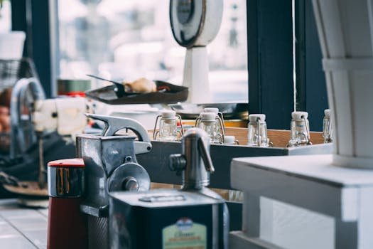 Close-up of kitchen counter with machinery and glass bottles indoors.