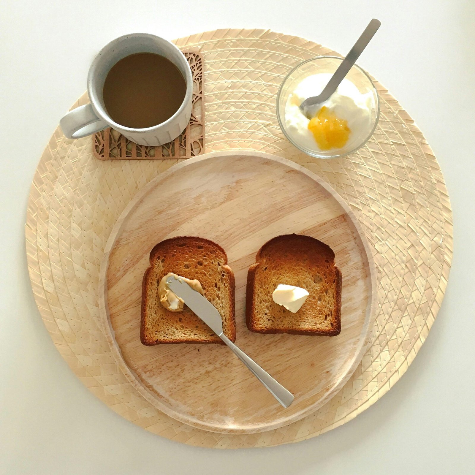 Minimalist breakfast setup with toast, butter, coffee, and yogurt.
